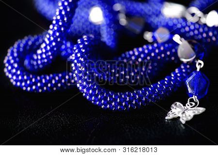 Long Open Necklace (lariat) Blue Color On A Dark Background Close Up