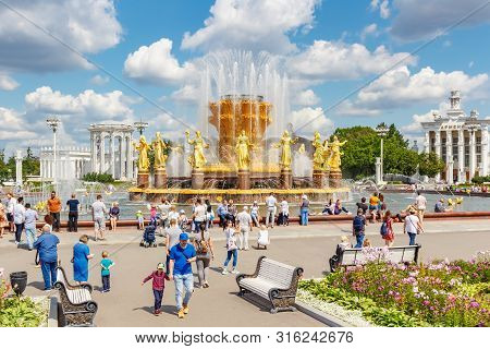 Moscow, Russia - July 22, 2019: Tourists Walking On Square Near Friendship Of Peoples Fountain In Vd