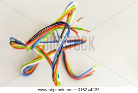 Electric Wires Of Different Colors In Curved Form On A Gray Background