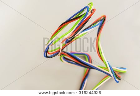 Electric Wires Of Different Colors In Curved Form On A Gray Background