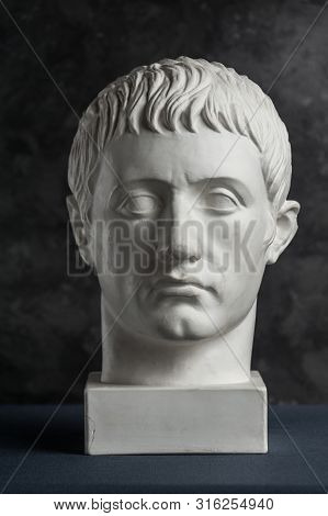 Gypsum Copy Of Ancient Statue Germanicus Head On Dark Textured Background. Plaster Sculpture Man Fac