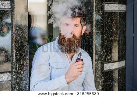 Bearded Man Smoking Vape. Man With Beard Breathe Out Smoke. Clouds Of Flavored Smoke. Smoking Electr