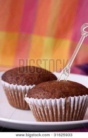 Two piece of banana cake with a fork and background colorful