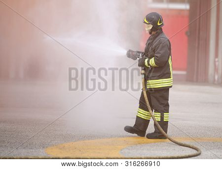 Fireman In Action With Foam During A Fire