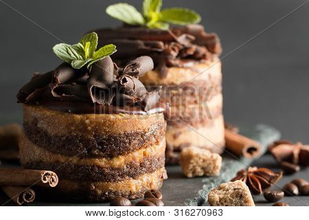 Dark Chocolate Cakes On Black Slattern Board With Mint, Cinnamon, Coffee Beans On A Wooden  Backgrou