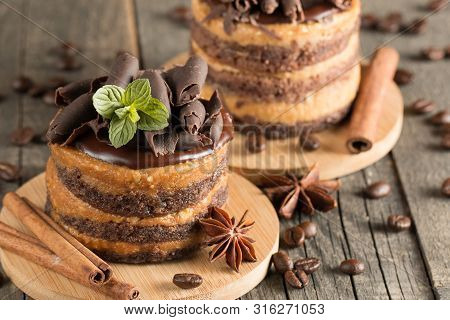 Dark Chocolate Cakes On Black Slattern Board With Mint, Cinnamon, Coffee Beans On A Wooden  Backgrou