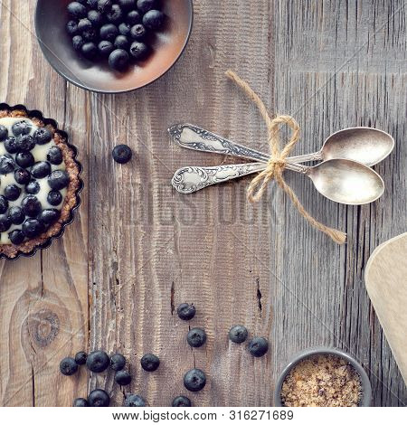 Top View On Wholegrain Blueberry Tarts With Vanilla Cream On Rustic Wooden Background