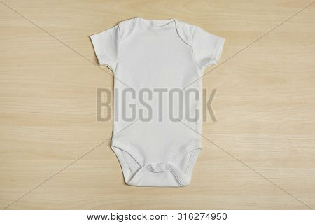 Cute Baby Onesie On Wooden Background, Top View