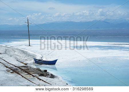Salt Lake landscape with blue boat, named Chaka Salt Lake, is located in Qinghai Province, China.                 