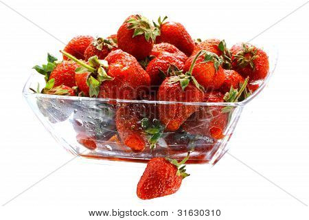 Muchos fresas apetecibles en el recipiente de vidrio