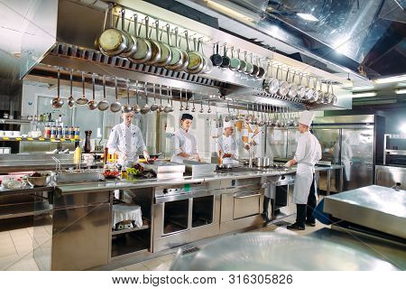 Modern Kitchen. The Chefs Prepare Meals In The Restaurants Kitchen