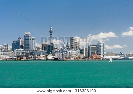 Auckland, New Zealand - December 9, 2012: Auckland Skyline With Sailboat And Blue Sky