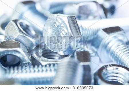 Metal Bolts And Nuts  In A Row Background. Chromed Screw Bolts And Nuts Isolated. Steel Bolts And Nu