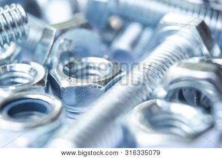 Metal Bolts And Nuts  In A Row Background. Chromed Screw Bolts And Nuts Isolated. Steel Bolts And Nu