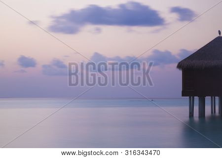 Bungalow Over The Water At Sunset. Long Exposure. Tranquil Sea.
