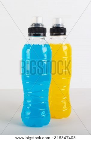 Isotonic Energy Drink. Bottles With Blue And Yellow Transparent Liquid, Sport Beverage On A White Ba