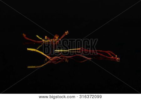Group Of Three Whole Dry Shaffron Thread Isolated On Black Glass