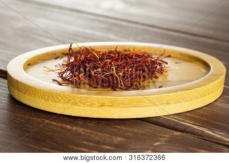 Lot Of Whole Dry Shaffron Thread On Bamboo Plate On Brown Wood