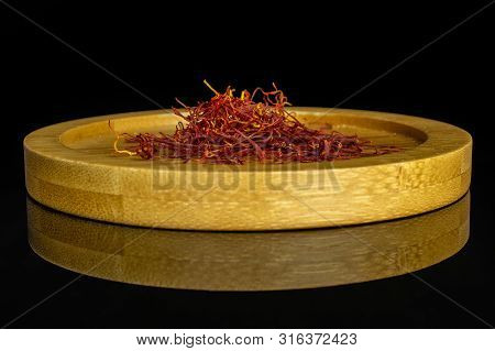 Lot Of Whole Dry Shaffron Thread On Bamboo Plate Isolated On Black Glass