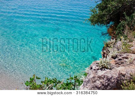 Beautiful Sandy Beach With Rock And Blue Clear Water