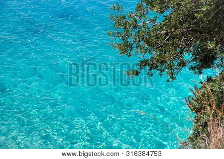 Beautiful Sandy Beach With Rock And Blue Clear Water