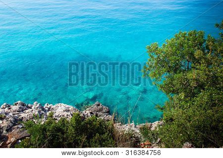 Beautiful Sandy Beach With Rock And Blue Clear Water