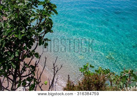 Beautiful Sandy Beach With Rock And Blue Clear Water