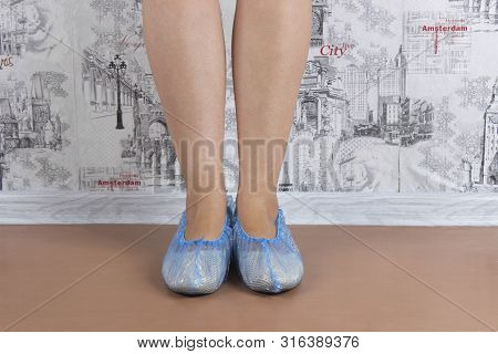 Woman Puts On Blue Shoe Covers, Close Up