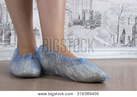 Woman Puts On Blue Shoe Covers, Close Up