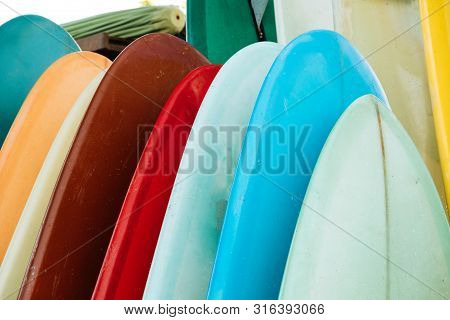 Set Of Colorful Surfboard For Rent On The Beach. Multicolored Surf Boards Different Sizes And Colors