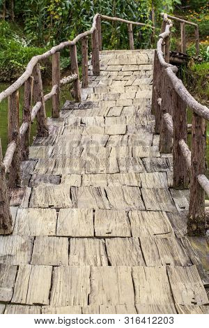 Old Wooden Bridge Over A Stream, Vertical Photo