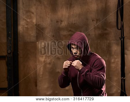 Portrait Of Young Healthy Man Kickboxing In Modern Gym