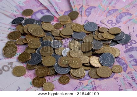 Ukrainian Banknotes Value Of 200 Hryvnia Uah And Pile Of Coins.