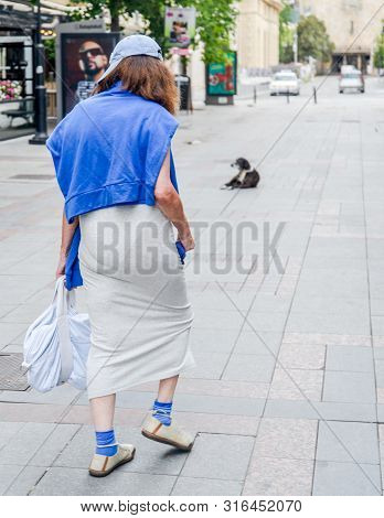 Skopje/north Macedonia-august 27 2018:woman Wearing A Baseball Cap Walks Down A Street In Skopje Cit