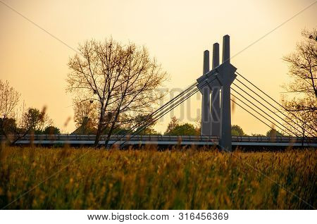 Pillars Of The Road Bridge Across The River Werre Looking From The Grass During The Sunset