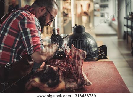 Chef cutting beef carcass in a restaurant