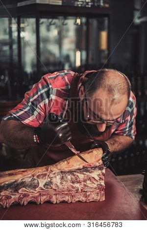 Chef cutting beef carcass in a restaurant