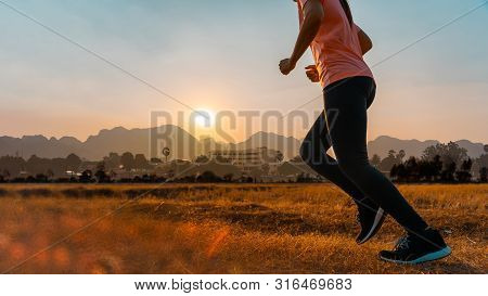 Asian Woman Enjoys Running Outside With Beautiful Summer Evening In The Countryside.