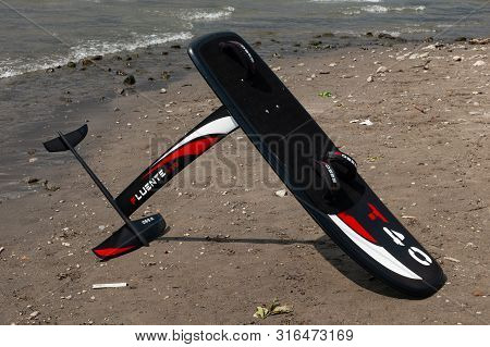 Lake Como, Italy - July 21, 2019. Windfoil Gear On A Beach Near Water. Windsurf Foiling Is New Style