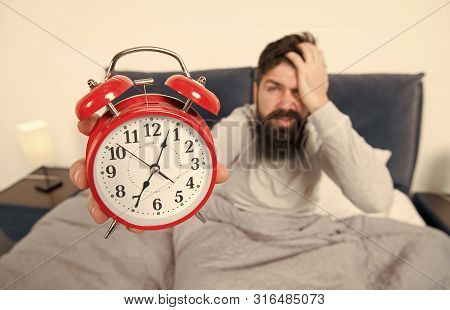 Tips For Becoming An Early Riser. Man Bearded Hipster Sleepy Face In Bed With Alarm Clock. Problem W