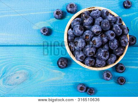 Raw Fresh Huckleberry In A Bowl. Wooden Background.