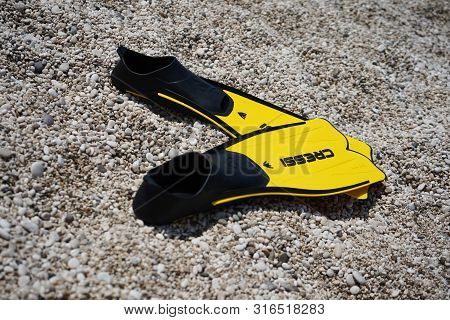 Lefkada, Milos Beach, Greece, Augest 11, 2019. Swimming Flippers Cressi Lie On The Stones On The Bea