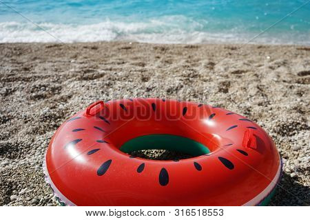 Bright Rubber Ring On The Beach Against The Sea