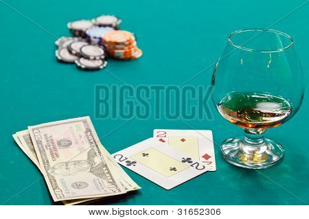 et glas spiritus og kort og dollars