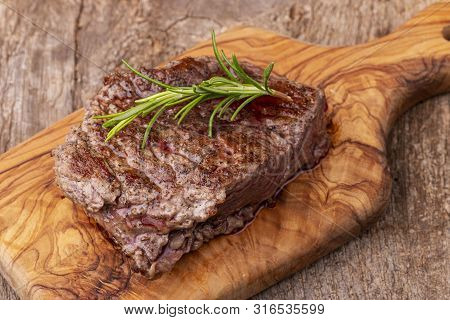 Overview Of Grilled Steak On Wood With Rosemary