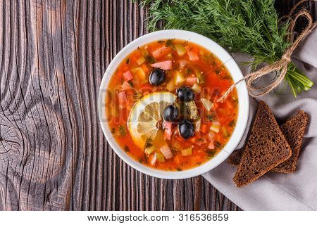 Traditional Russian Meat Soup Solyanka In Bowl On Rustic Wooden Table