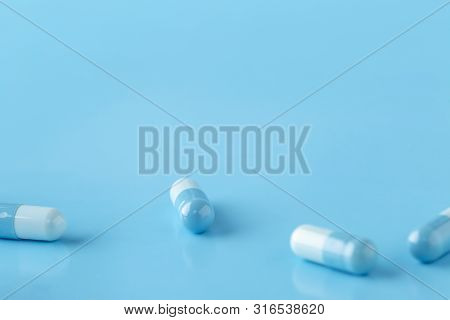 Various White-blue Medication Capsules. Blue Background With Text Space