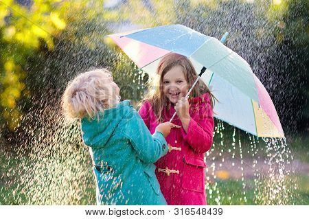 Kids With Umbrella Playing In Autumn Shower Rain.