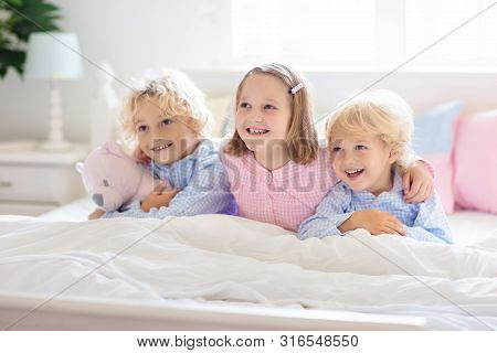 Kids Play In Bed. Children At Home.