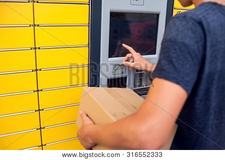 Client Using Automated Self Service Post Terminal Machine Or Locker To Deposit A Parcel For Storage